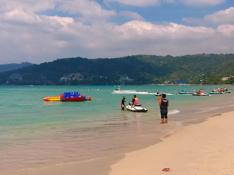 group of friends working on Phuket beach with laptops Thailand