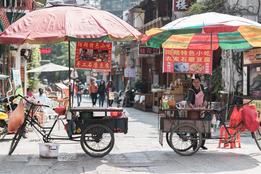 friends sharing hot pot street food Hainan China 2026