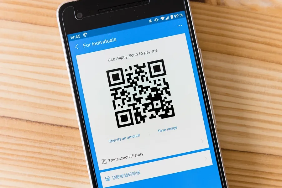 Человек оплачивает покупку через Alipay в Китае