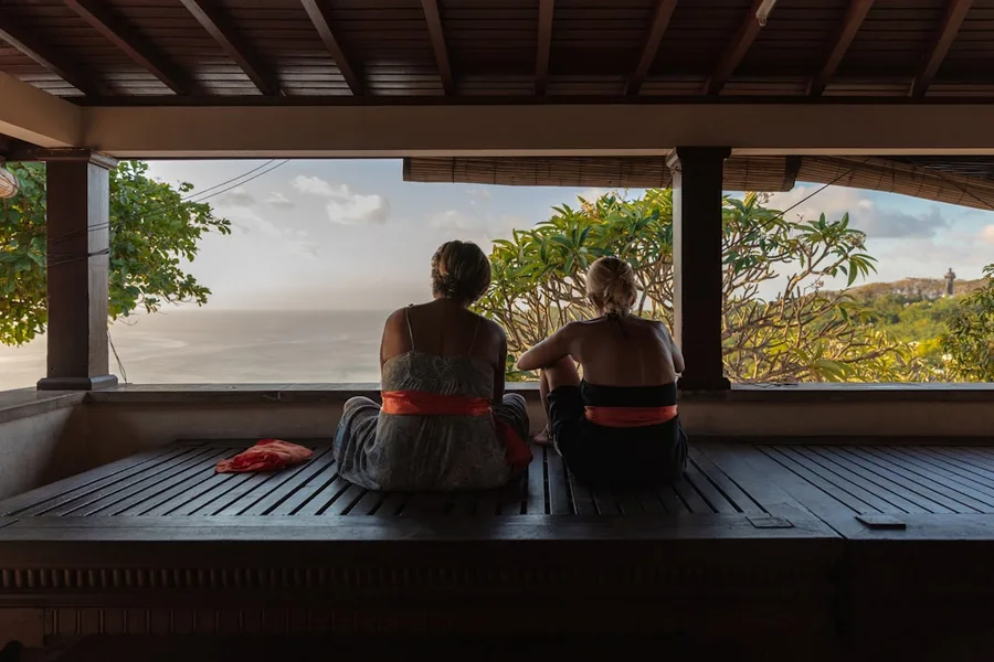 Uluwatu temple sunset Bali Indonesia with tourist checking mobile data